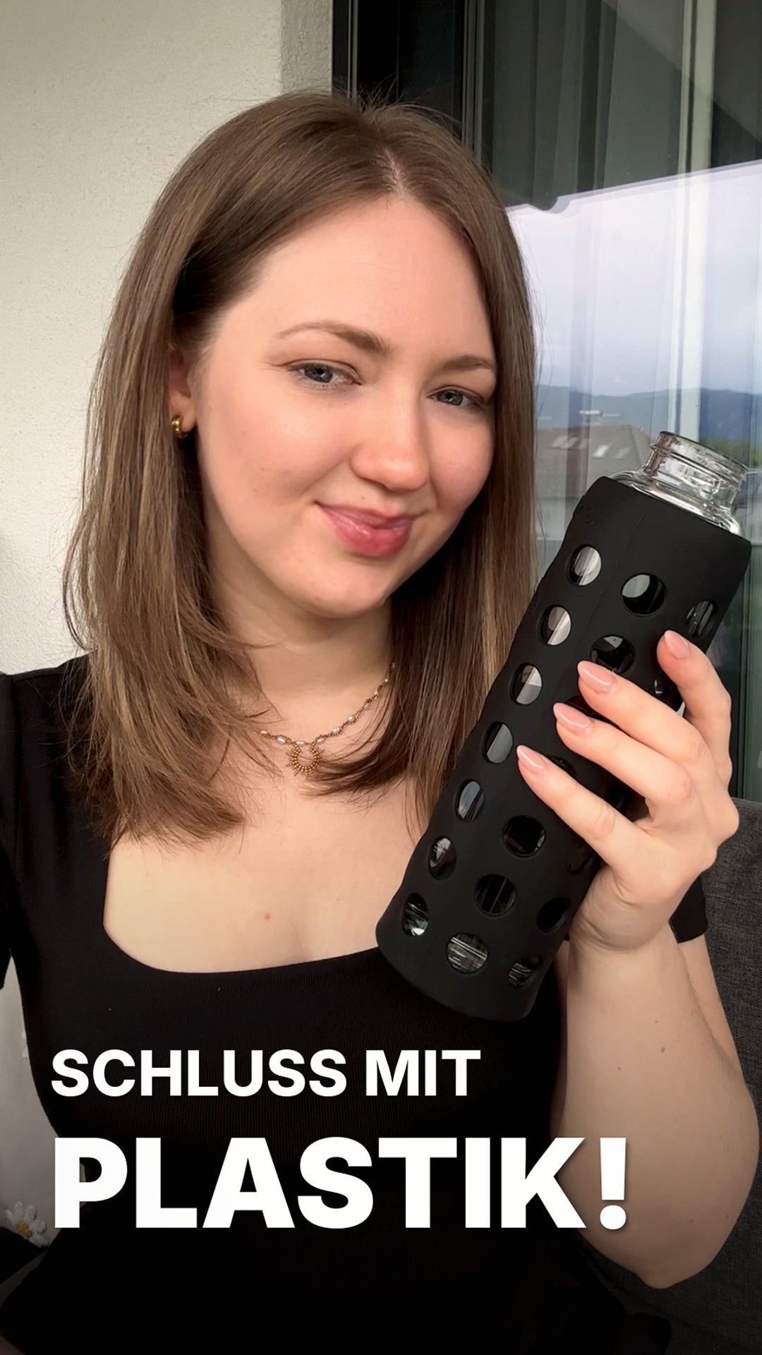 Load video: Eine junge Frau hält eine spottle Glasflasche in die Kamera und erklärt, warum sie Glas gegenüber Plastik bevorzugt – insbesondere wegen des neutralen Geschmacks und des angenehmen Trinkgefühls.