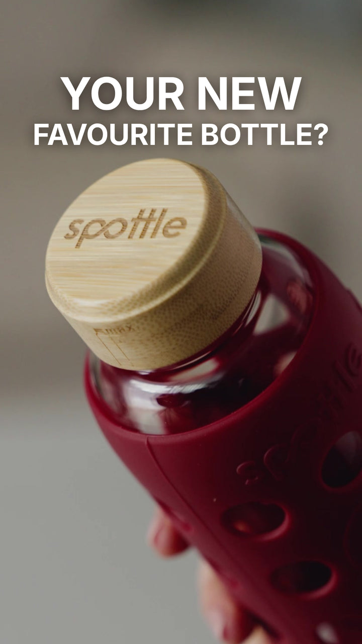 A spottle glass water bottle with a Berry silicone sleeve is unboxed, filled with water and placed in the dishwasher with the lid removed.